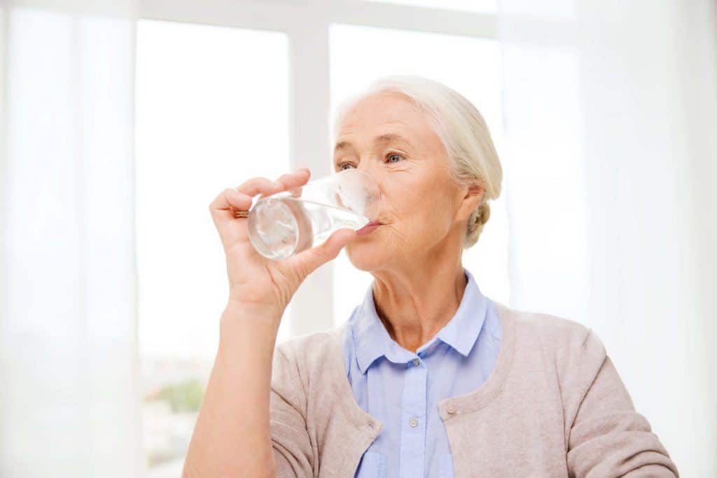 elderly woman drinking water